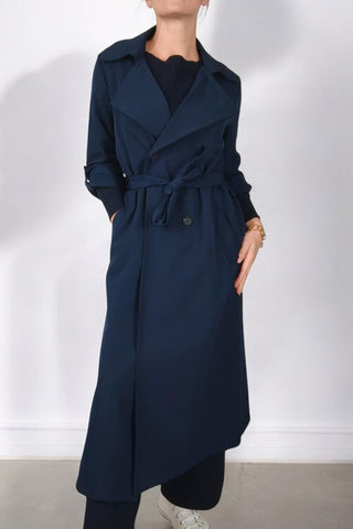 Trench lungo con collo a revers e chiusura doppiopetto. Cintura in vita per valorizzare la silhouette e maniche a 3/4 con risvolto fissato da bottone. Un capo classico e versatile, perfetto per un look elegante e contemporaneo.