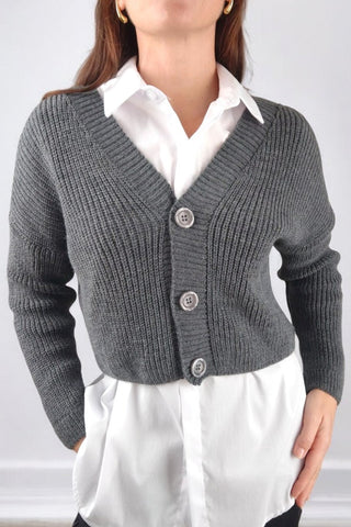 Cardigan corto in maglia con scollo a V e chiusura a 3 bottoni. Presenta maniche lunghe e una vestibilità versatile, ideale da abbinare sia a look casual che più raffinati.