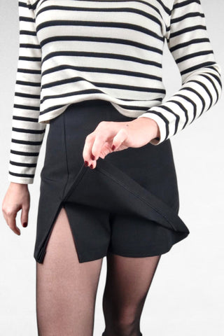 Gonna mini con shorts integrati, dotata di un piccolo spacco frontale per un tocco moderno. Chiusura laterale con zip per una vestibilità comoda e pratica, unisce lo stile di una gonna con la sicurezza del pantaloncino sottostante.