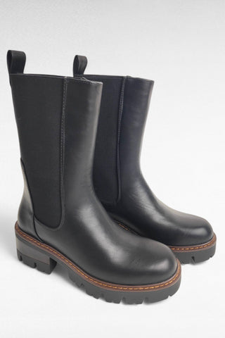 Stivale realizzato in materiale sintetico nero con finitura similpelle. La parte posteriore della tomaia è in tessuto elastico, tipico dei Chelsea boots, per garantire una calzata facile e un’aderenza confortevole alla gamba. Il bordo superiore è completato da una linguetta posteriore che ne facilita ulteriormente la vestibilità.