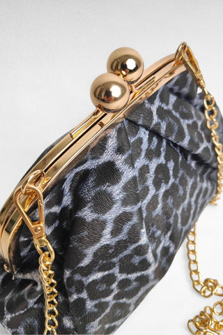 Elegante clutch in ecopelle con fantasia animalier, perfetta per aggiungere un tocco grintoso a qualsiasi outfit. La chiusura in metallo dorato dona un accento raffinato, mentre la possibilità di aggiungere la tracolla la rende versatile per un uso sia a mano che a spalla. Un accessorio di tendenza, ideale per completare look sia da giorno che da sera.