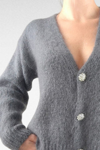 Cardigan caldo e morbido, impreziosito da bottoni gioiello per un tocco di eleganza. Perfetto da indossare come strato aggiuntivo, unisce comfort e raffinatezza.