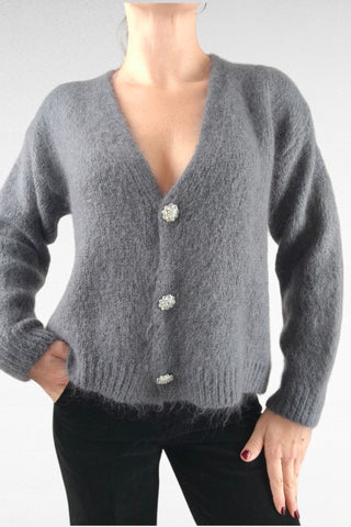 Cardigan caldo e morbido, impreziosito da bottoni gioiello per un tocco di eleganza. Perfetto da indossare come strato aggiuntivo, unisce comfort e raffinatezza.