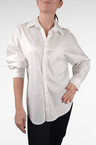 Camicia bianca dal taglio classico con colletto a revers, particolare della camicia un’arricciatura sul retro all’altezza della vita, che dona movimento e valorizza la silhouette con eleganza.