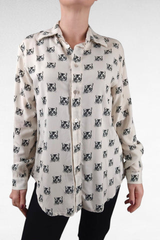 Camicia dal taglio classico con colletto a revers leggermente più lunga sul retro. Decorata con una fantasia originale di gatti, aggiunge un tocco spiritoso e moderno al tuo stile.