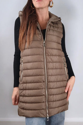 Cappotto lungo con collo classico a revers, chiusura con bottoni automatici e cintura in vita. Dotato di un'imbottitura interna staccabile, che può essere utilizzata separatamente come gilet con cappuccio. Presenta tasche e polsini realizzati nello stesso tessuto imbottito del gilet, rendendolo un capo versatile e adatto a diverse temperature.