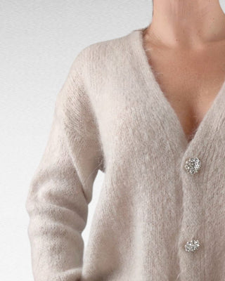 Cardigan caldo e morbido, impreziosito da bottoni gioiello per un tocco di eleganza. Perfetto da indossare come strato aggiuntivo, unisce comfort e raffinatezza.