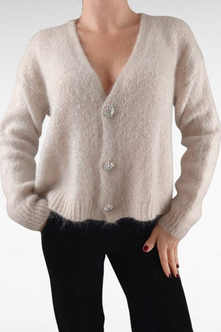 Cardigan caldo e morbido, impreziosito da bottoni gioiello per un tocco di eleganza. Perfetto da indossare come strato aggiuntivo, unisce comfort e raffinatezza.