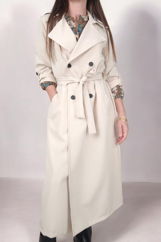 Trench lungo con collo a revers e chiusura doppiopetto. Cintura in vita per valorizzare la silhouette e maniche a 3/4 con risvolto fissato da bottone. Un capo classico e versatile, perfetto per un look elegante e contemporaneo.