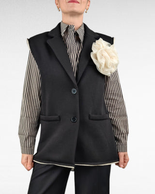 Gilet lungo in felpa, con collo raglan e chiusura a due bottoni. Arricchito da una spilla a forma di fiore applicata sul davanti, è un capo versatile e originale, perfetto per aggiungere un tocco di stile al tuo look casual.