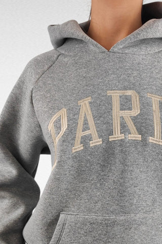 Felpa con cappuccio dal taglio classico, caratterizzata dalla scritta "Paris" sul davanti. Realizzata in tessuto morbido e confortevole, è perfetta per un look casual e urbano.