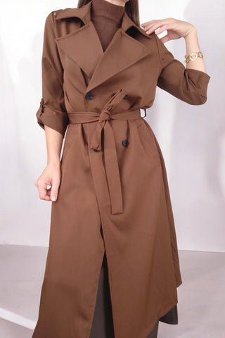 Trench lungo con collo a revers e chiusura doppiopetto. Cintura in vita per valorizzare la silhouette e maniche a 3/4 con risvolto fissato da bottone. Un capo classico e versatile, perfetto per un look elegante e contemporaneo.