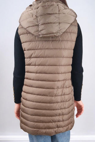 Cappotto lungo con collo classico a revers, chiusura con bottoni automatici e cintura in vita. Dotato di un'imbottitura interna staccabile, che può essere utilizzata separatamente come gilet con cappuccio. Presenta tasche e polsini realizzati nello stesso tessuto imbottito del gilet, rendendolo un capo versatile e adatto a diverse temperature.